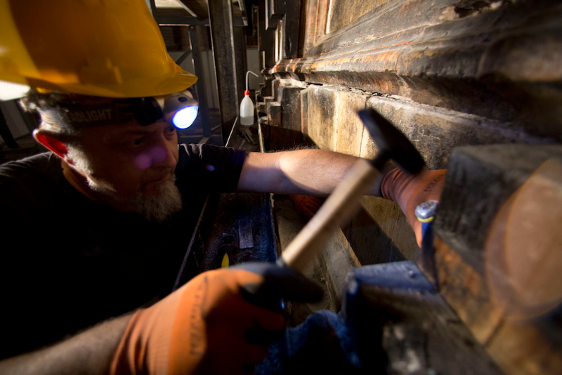 A Greek restoration expert clearing centuries of grime way from the tomb’s walls